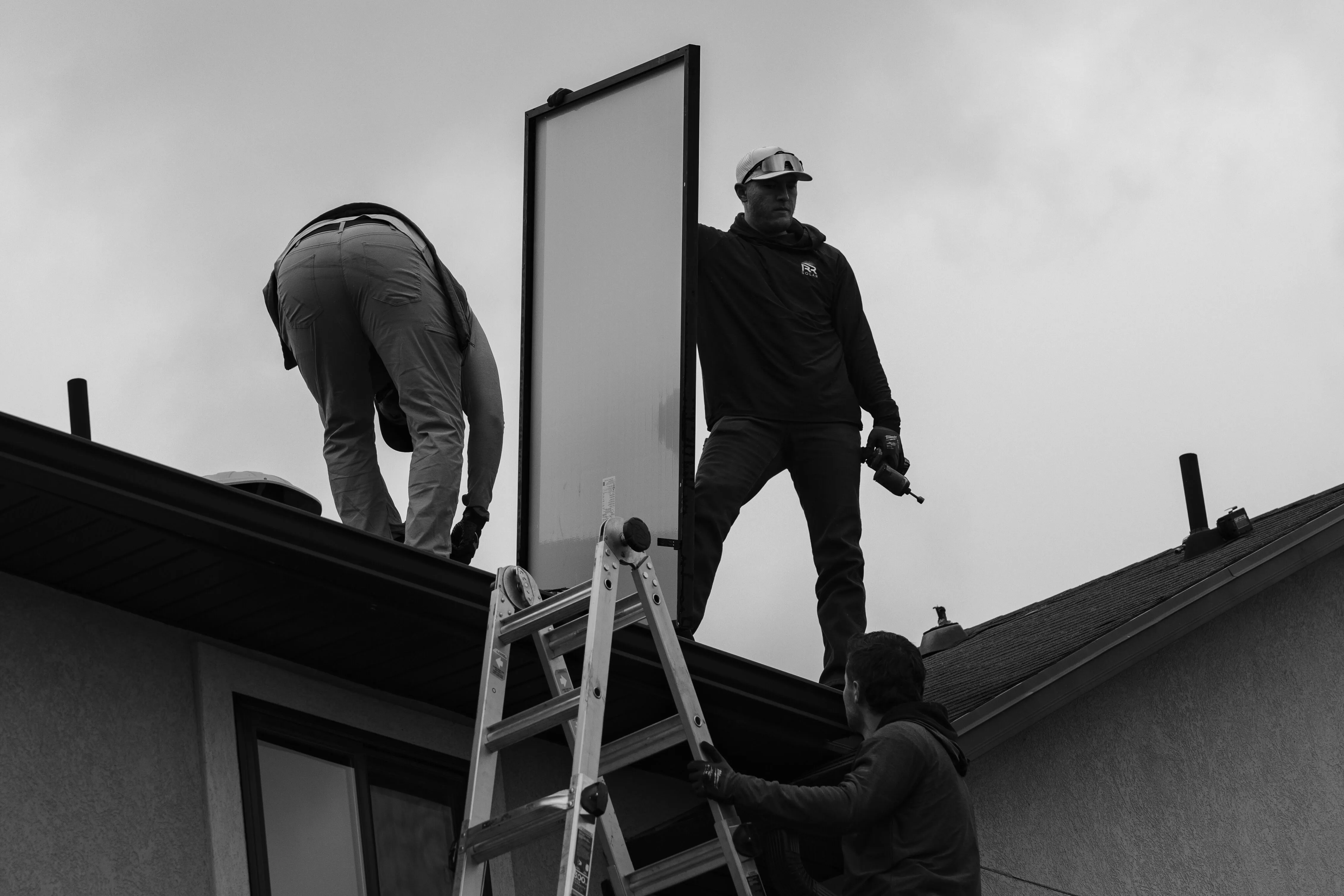 R&R Solar Roofs technicians removing a solar panel from a Utah roof